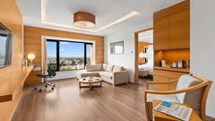 Side view of the Club Suite living room with a cozy sofa in the corner and a view from the window at The Residency Towers Coimbatore