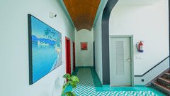 Spacious hallway of the Elite Room at The Sierra By The Lake featuring soothing blue walls, elegant artwork, and natural light leading towards the private balcony.