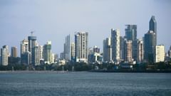  A long view of Mumbai city from the sea, where the skyline and building outlines are visible in the distance.
