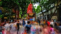 A crowd walking on the streets along a procession.