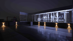 A night view of the Tulip Inn Gurugram rooftop terrace featuring a modern illuminated glass railing and warm floor lighting.