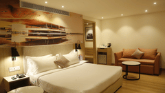 A bedroom with warm tones, a king size bed, and cosy decor - Tulip Inn, Zirakpur