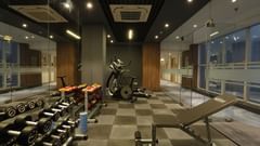  An image of a gym featuring various fitness equipment like dumbbells, wights, treadmills, and benches at Tulip Inn, Zirakpur