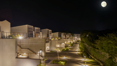 Night view of the landscaped pathways and guest buildings at Vandhara Sarovar Premiere, Patkote, under a bright moon.