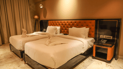 Two single beds with cushioned headboards and side tables inside of the rooms - VITS Bharat Nanded