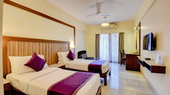 Spacious bedroom with king-size bed and purple décor accents at VITS Lonavala.