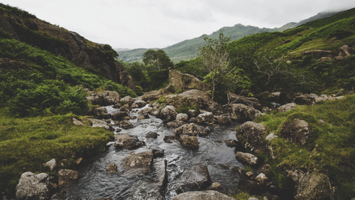 A river flows through a valley with mountains on either side.