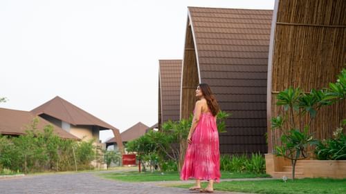 Woman walking through a pathway near an array of villas at Ananta Spa and Resort, Ajabgarh.