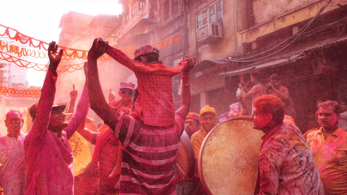 people playing with colours on the street with drums