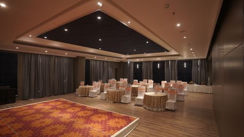 banquet hall decorated with a stage, tables and chairs at Classic Sapphire by Ananta