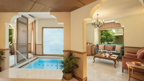 Indoor plunge pool and seating area at Heritage Village Resorts & Spa, Manesar with a classic decor and ambient lighting.