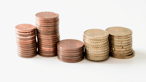 A close up shot of many coins stacked on top of each other in a pile of five