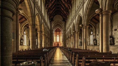 interior view of a cathedral with benches and an altar in view in the distance