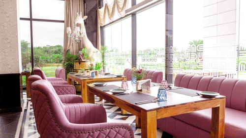 Seating arrangements inside On Kourse at Karma Lakelands with floor to ceiling windows.