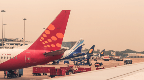 A view of different Bengaluru to Goa Flights parked at an airport with baggage at the bottom.