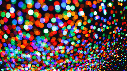 a close up shot of lights during a carnival with many different lights in blur