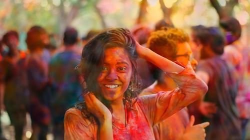 a girl posing for a picture while being drenched in colours