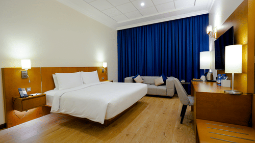 A double bed with side tables and lamps inside Classic Premium King - La Maison Hotel, Doha