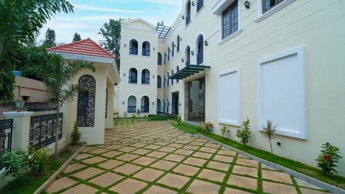 The facade of MGM Whispering Meadows (Residency) with close knit buildings and trees.