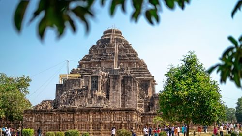 A pyramid-shaped temple complex, adorned with intricate carvings, surrounded by trees and people - Places of interest in Gwalior