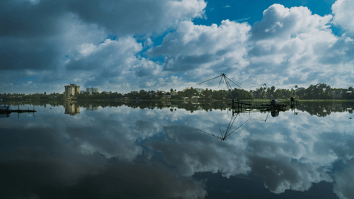 Backwaters under a cloudy sky with patchy clouds reflecting on the water