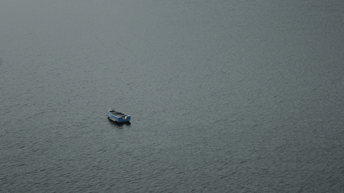 A far out view of a solitary boat on the waters of Siliserh Lake.
