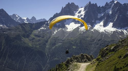 A person paragliding through serene mountains