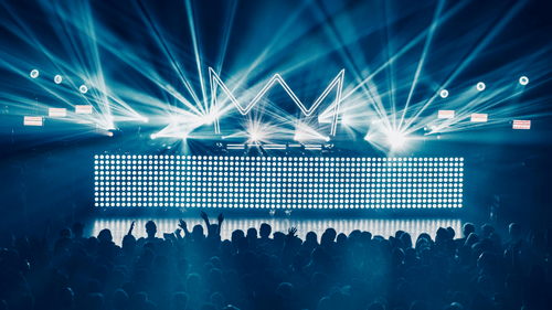 Concert stage illuminated with blue and white lights during a live music performance.