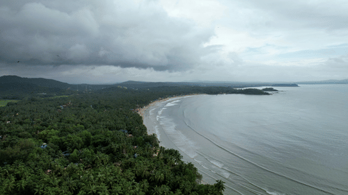 an overview of Palolem Beach in South Goa with greenery and blue skies in the background, for the perfect New Year in South Goa.