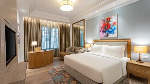 a double bed, side table, work desk, and television in one of the rooms at Park Plaza, Jalandhar