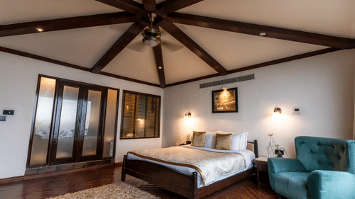 Spacious room with exposed beams, modern furniture, and natural lighting - Polo Cherrapunjee Resort