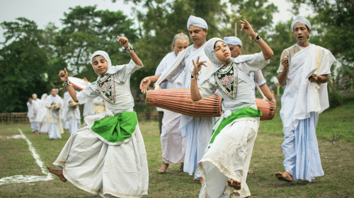 people dressed in native outfits while dancing and playing drums