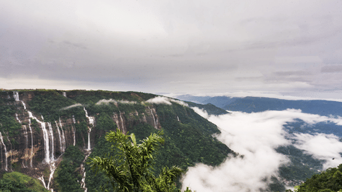 An image of a hill with several waterfalls and the horizon covered with clouds -  Polo Cherrapunjee Resort