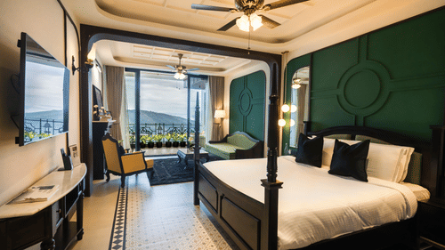 Bedroom with king size bed, flat TV screen, chair, sofa, and a view of the balcony - Polo Cherrapunjee Resort - Best Resorts Meghalaya