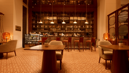 Mahua Bar at Prachi Sarovar Premiere, Bhubaneswar, featuring wooden tables, seating, patterned tiling, and a food display case under warm lights.