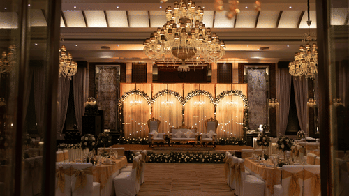 Grand wedding stage and banquet hall with crystal chandeliers.