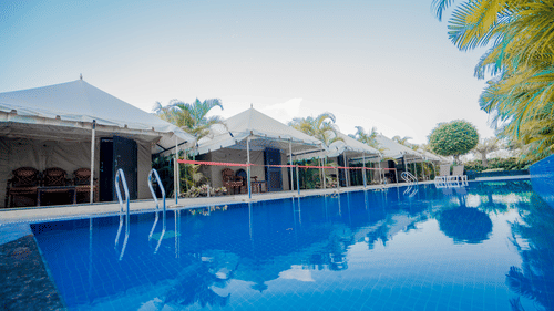 Image of tents placed on the pool deck near the swimming pool with crystal blue water at Pride Hotel and Convention Centre, Indore
