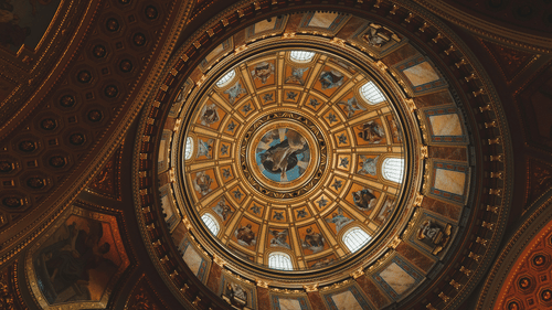 a view of a dome with intricate paintings as seen from below