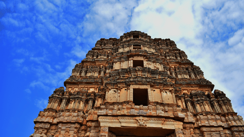 A stunning low-angle shot of a temple with intricate architecture set against the backdrop of a cloudy sky - Hotel near Tirupati temple