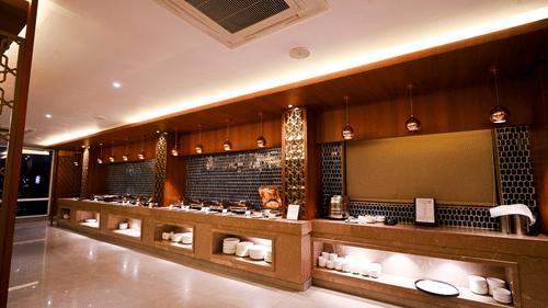 Reception area at Rivera Sarovar Portico, Ahmedabad showcasing a spacious front desk, warm lighting and contemporary interiors for guest check-in.