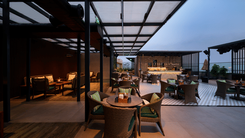 Covered rooftop dining area at Riviera Sarovar Portico, Pathankot with outdoor seating and a pleasant evening ambience.