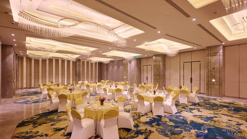 Banquet hall at Riviera Sarovar Portico, Pathankot arranged for formal events with elegant lighting and spacious seating layout.