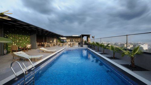 Rooftop swimming pool at Riviera Sarovar Portico, Pathankot surrounded by loungers and open skies, offering a refreshing leisure experience for guests.