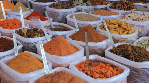 Colorful spices displayed in bags at an Indian market.