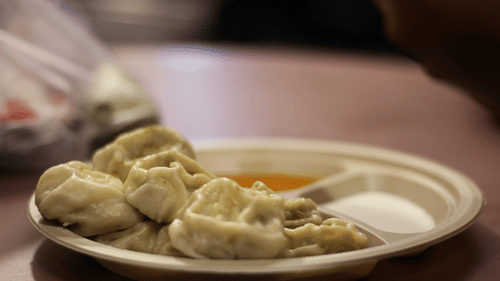 A plate of momos with different kinds of sauces served with it