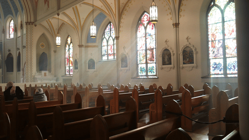 image showing the church seats and the painted glass on the windows