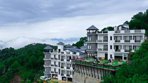 Facade image of Rosetum Kasauli as seen from afar with a mountain in the background