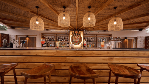 Indoor bar with high wooden stools, modern lighting, and a cosy ambience - Royal Tulip, Chitwan