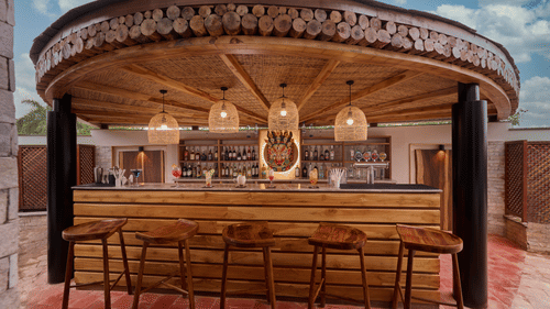 Round outdoor bar setup with stools and intricate wooden canopy design - Royal Tulip, Chitwan