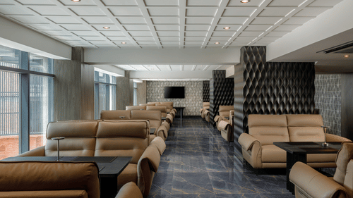 The comfortable and spacious lounge area at Royal Tulip, Kathmandu, with multiple sofas and a television.